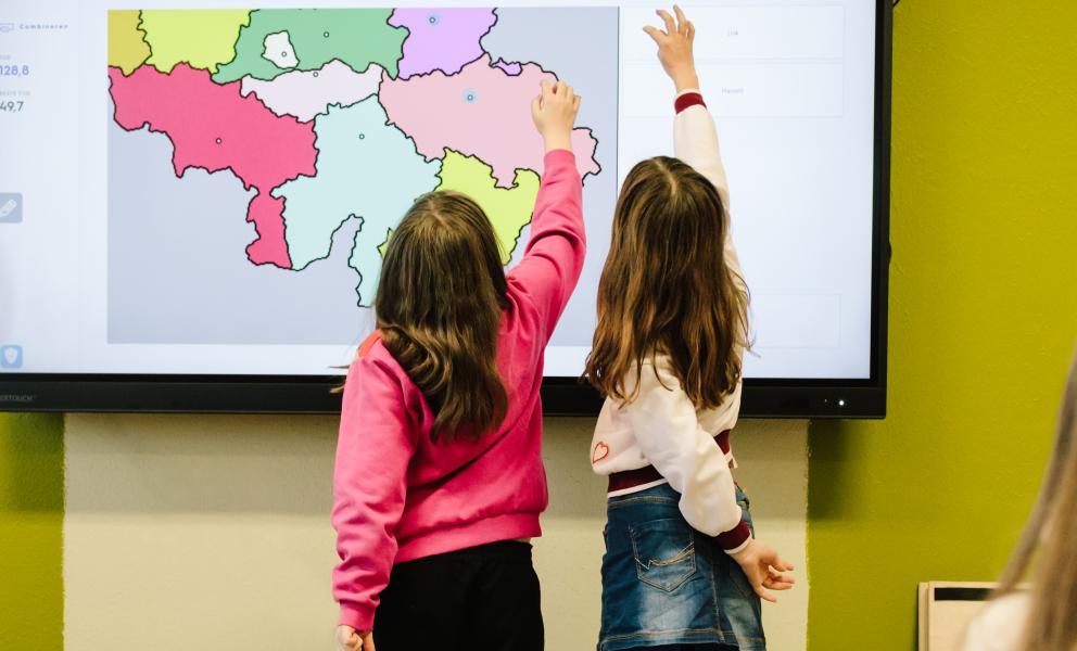 Twee leerlingen maken een oefening over de Belgische provincies op het smartbord