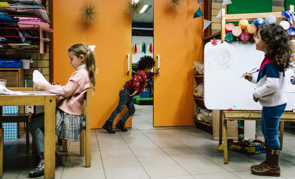 Kind schuift deur tussen klaslokalen open