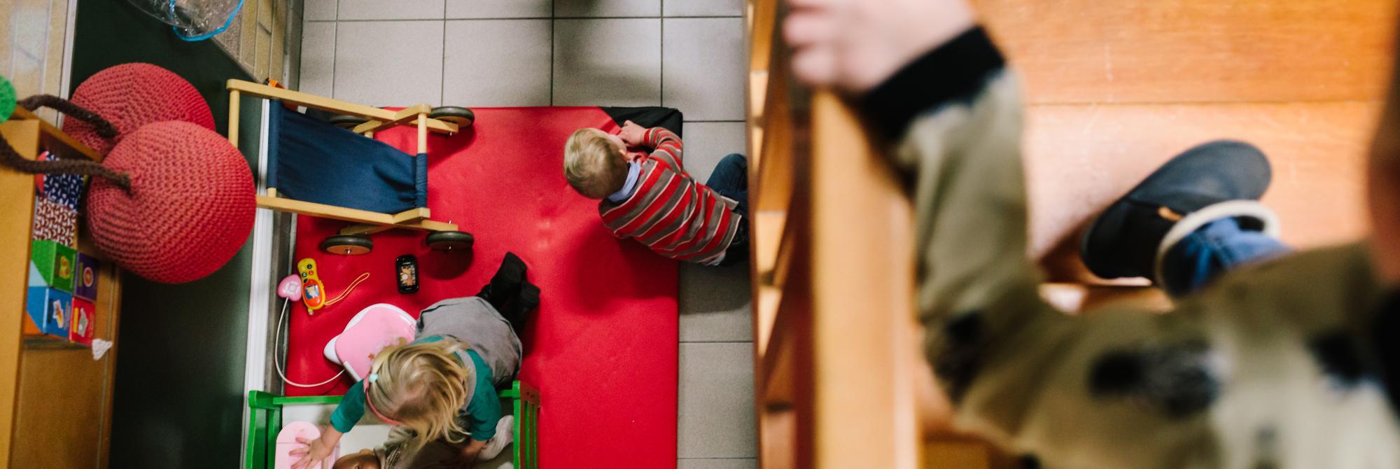 Kinderen komen van de trap met doorkijk naar speelhoek beneden