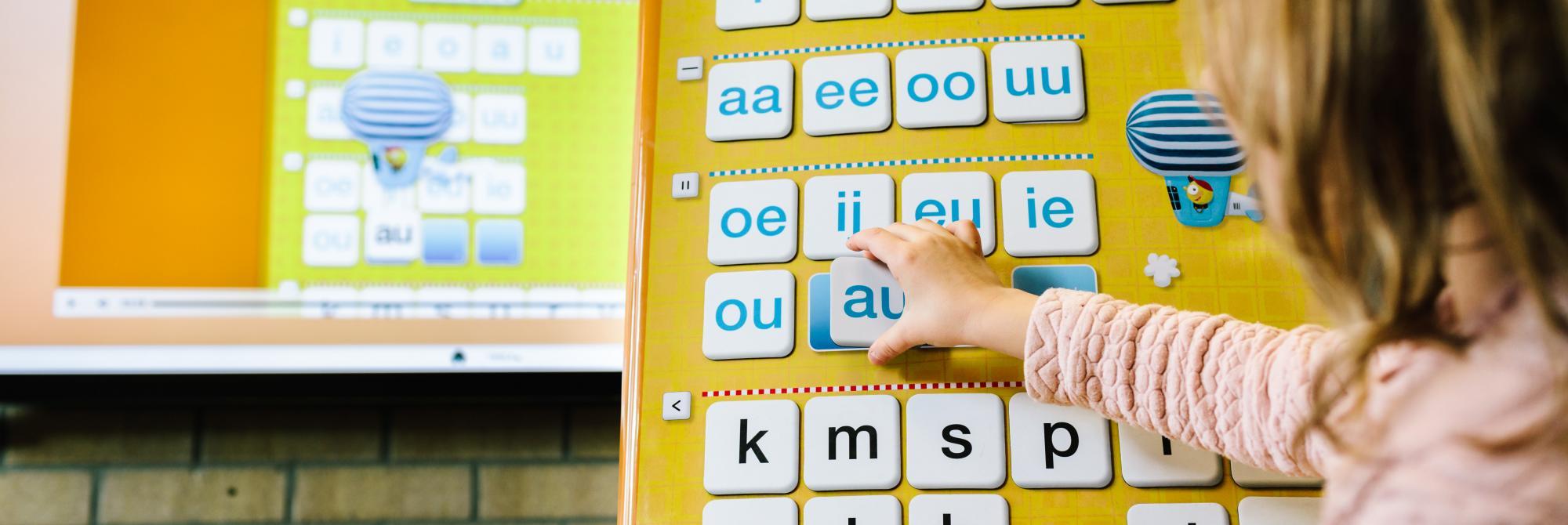 Kind legt letters op smartbord