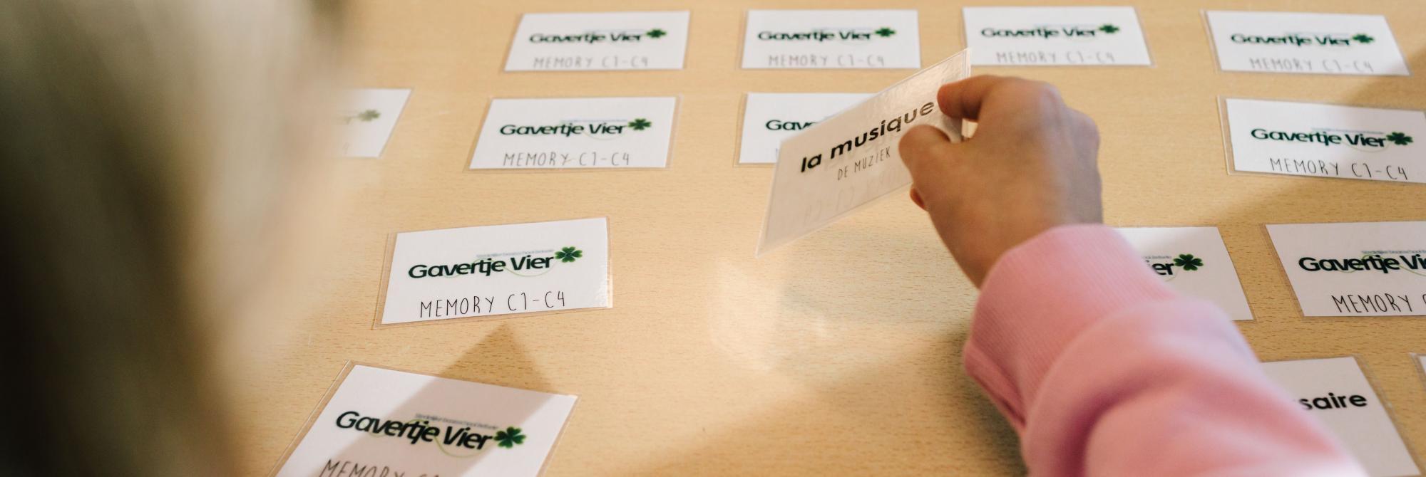 Handen van kind dat memory-spel met Franse woorden speelt